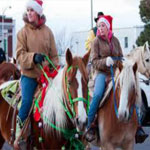 People in Santa Hats Riding Horses